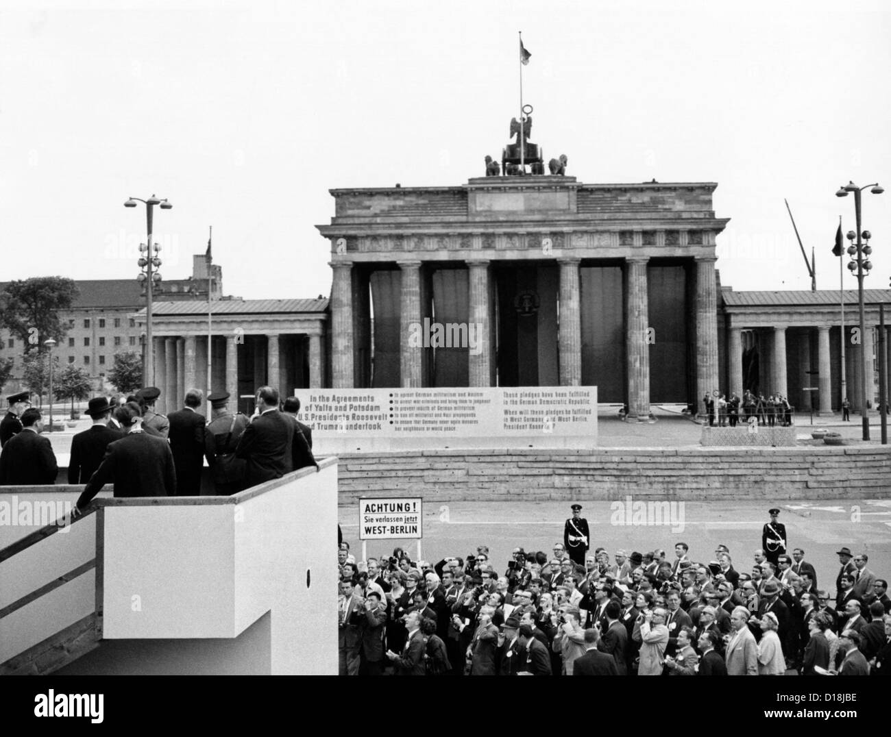 Il presidente John Kennedy visiti il muro di Berlino. Da una speciale piattaforma integrata presso la Porta di Brandeburgo, il presidente Kennedy sembra Foto Stock
