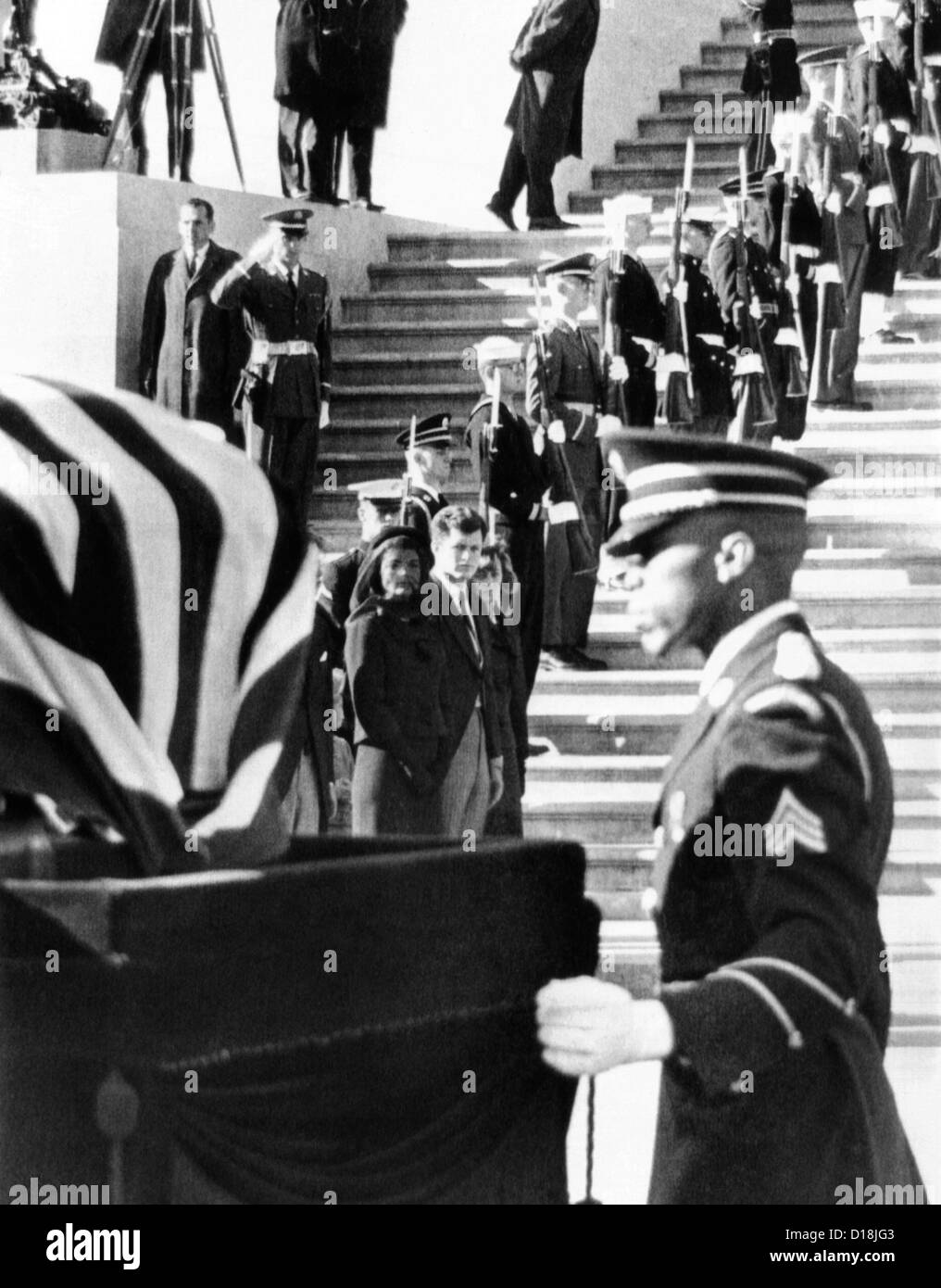 Jacqueline Kennedy, in una vedova del velo, orologi come bara contenente il corpo Presidente John Kennedy, viene posto sul cassone. Il Foto Stock
