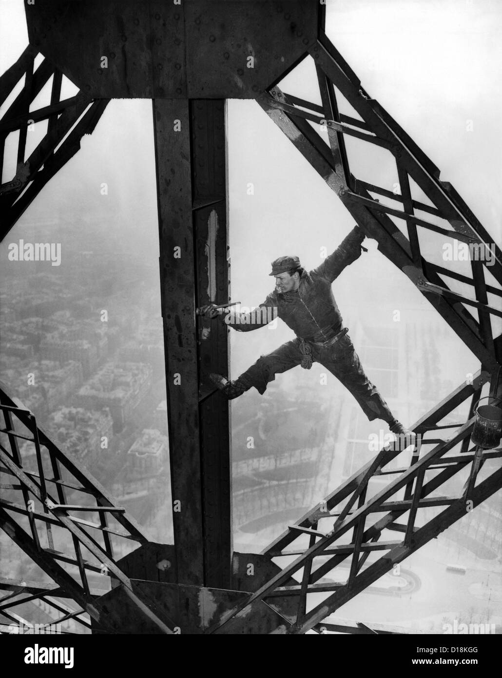 Lavoratore della pittura la Torre Eiffel. Lavorare senza un cavo di sicurezza egli precariamente si trova a cavallo di travi di acciaio. La torre viene Foto Stock