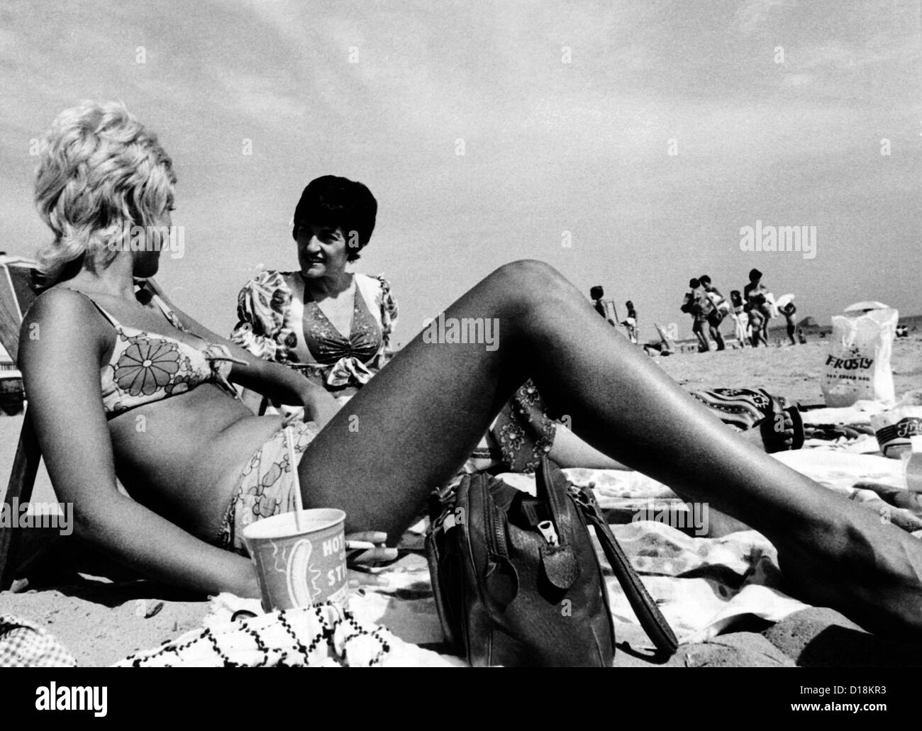 Le donne a prendere il sole sulla spiaggia di Santa Monica, California. Agosto 1970. (CSU ALPHA 1702) Archivi CSU/Everett Collection Foto Stock