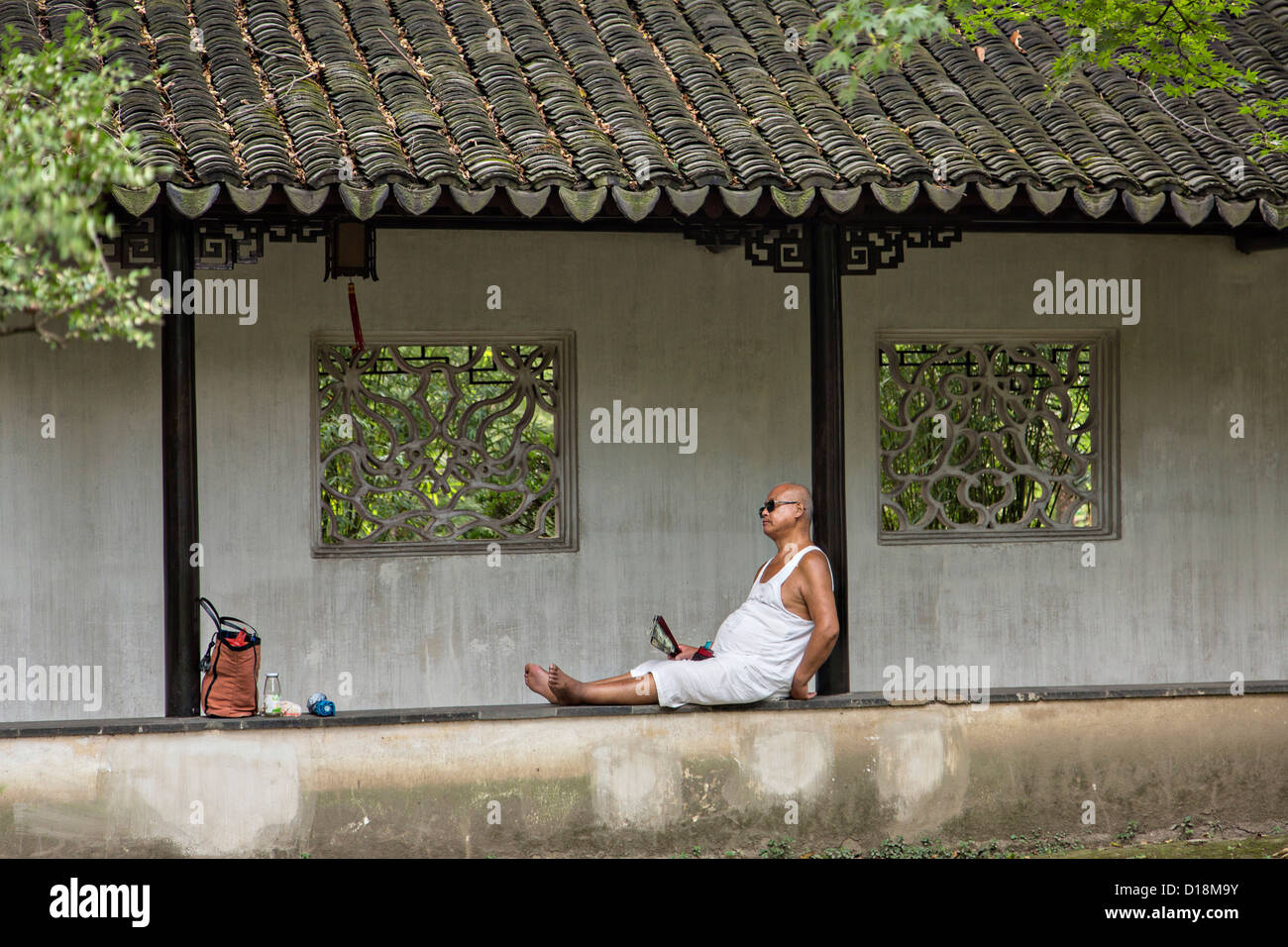 Un uomo cinese poggia nella umile Administrator's garden a Suzhou, Cina. Foto Stock