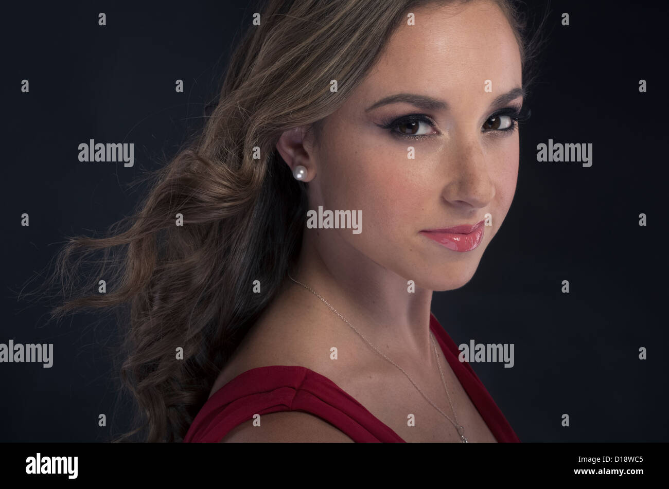 Donna con orecchini perla e semplice collana in rosso abito da sera Foto Stock
