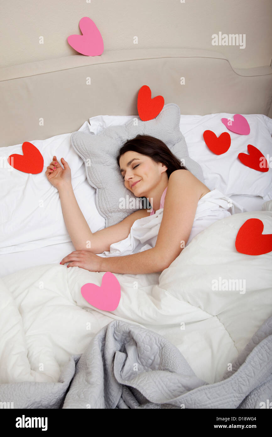 La donna a letto con forme di cuore sul coperchio Foto Stock