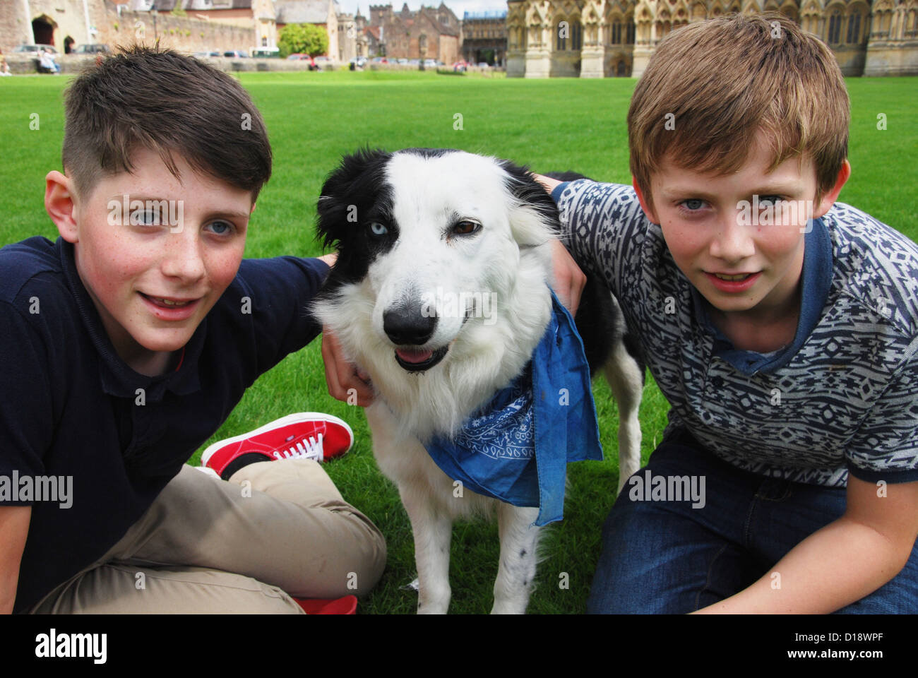 Due ragazzi e il loro cane nella parte anteriore della Cattedrale di Wells, Somerset REGNO UNITO Foto Stock