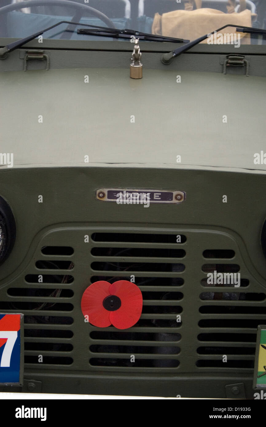 Un ricordo rosso papavero bloccati sulla parte anteriore di un classico jeep militari ad un auto show. Foto Stock