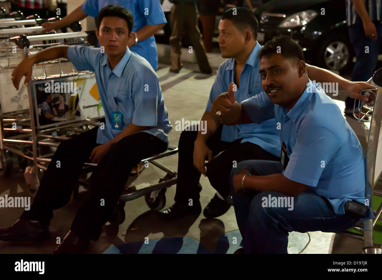 Facchini all'aeroporto di Bali in attesa per i clienti Foto Stock
