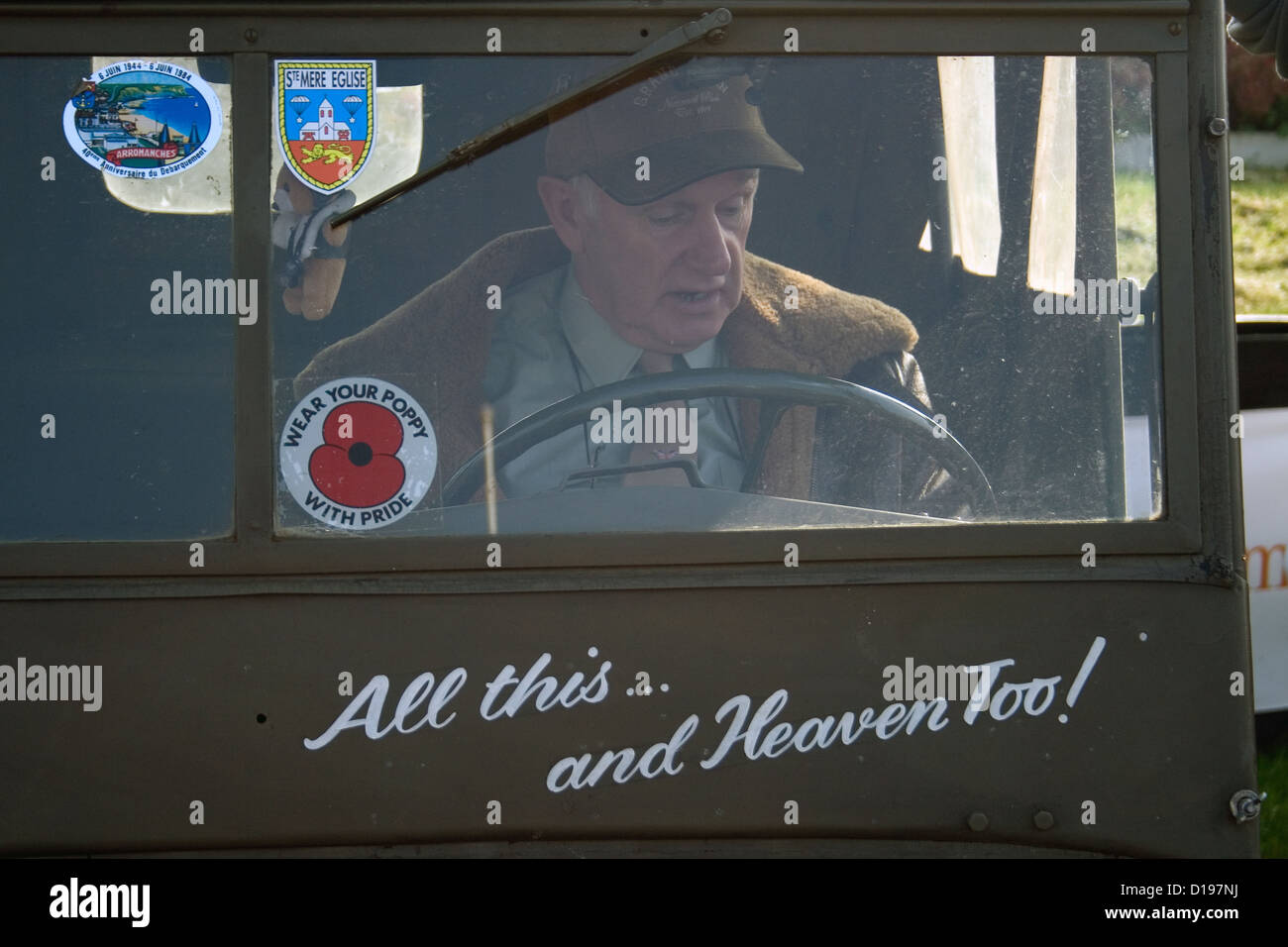 Un vecchio uomo seduto dietro al volante di un vintage americano jeep militari. Foto Stock