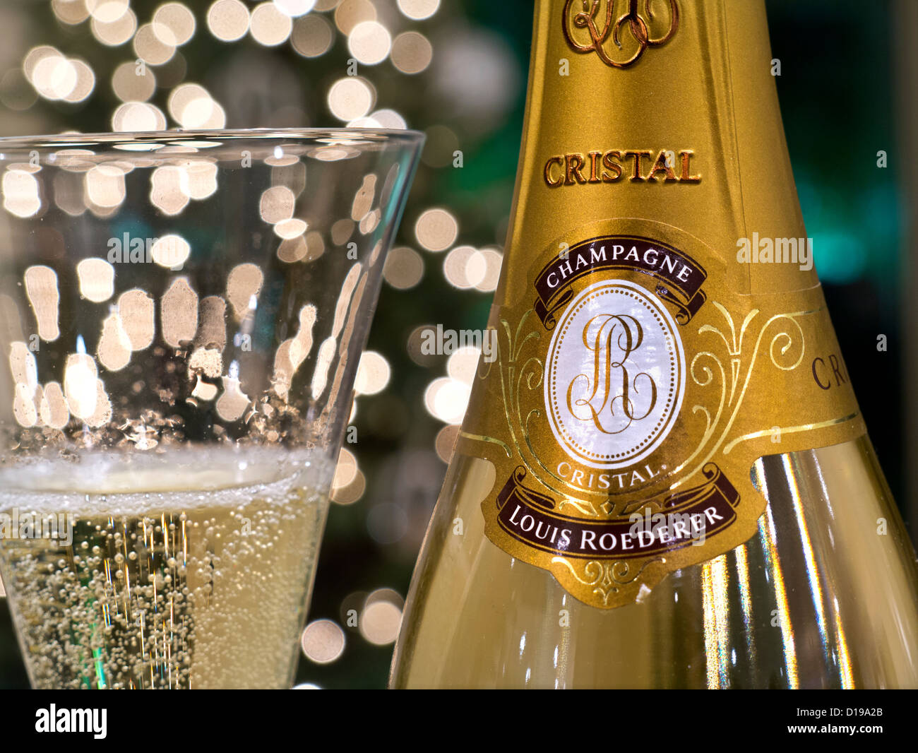 Bottiglia e spillata di fresco bicchiere di Louis Roederer Cristal champagne  di lusso con luci scintillanti in background Foto stock - Alamy