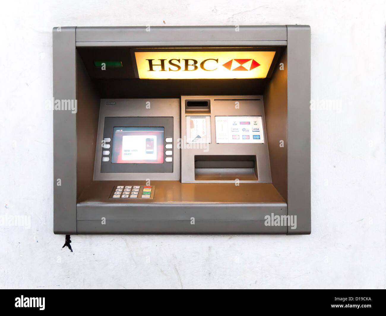 Bancomat ATM foro nella parete Automatic Teller HSBC Bank illuminato di luce della sera Foto Stock
