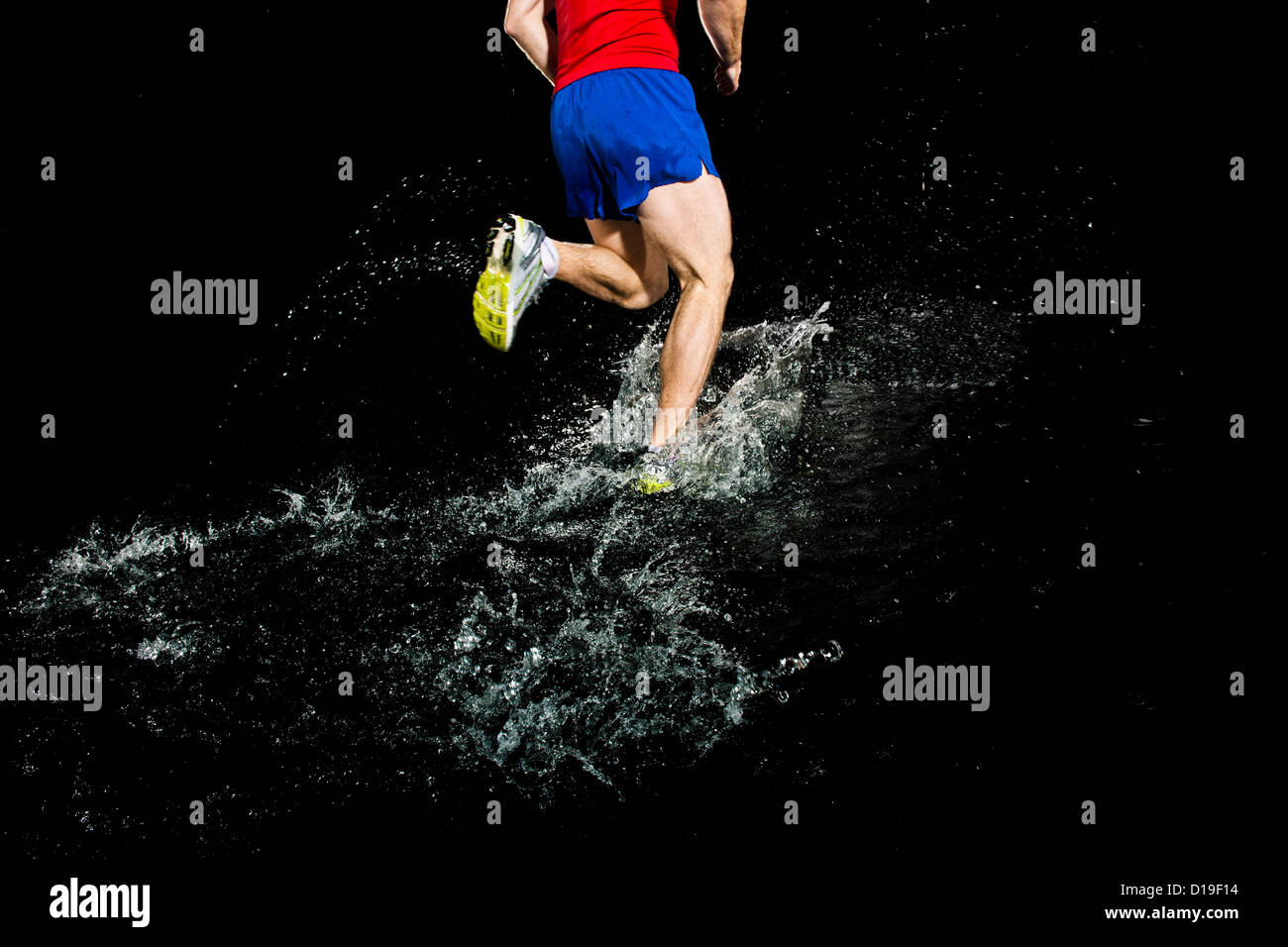 Runner schizzi attraverso l acqua Foto Stock