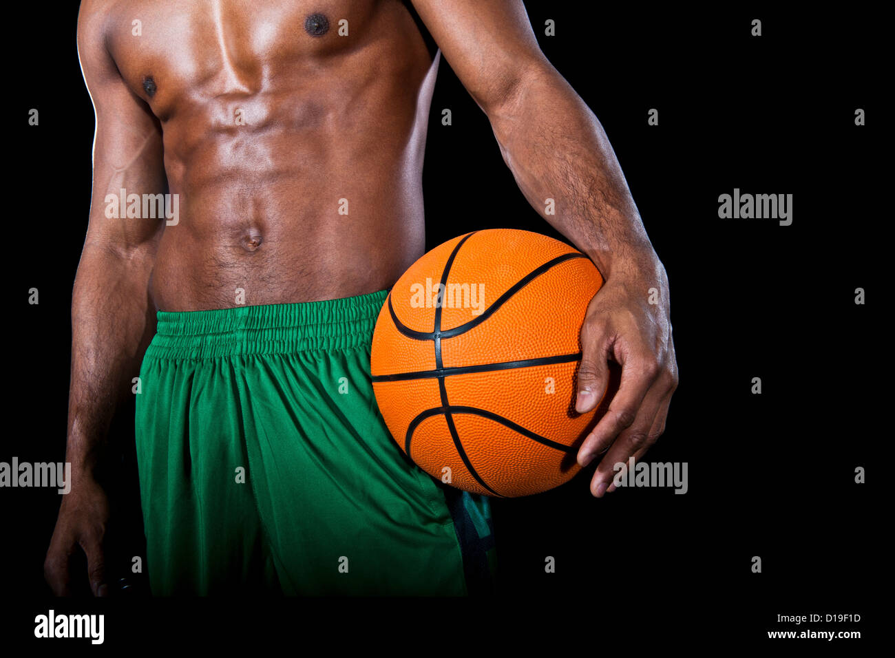 La sezione centrale del giocatore di basket con torace nudo, tenendo palla Foto Stock