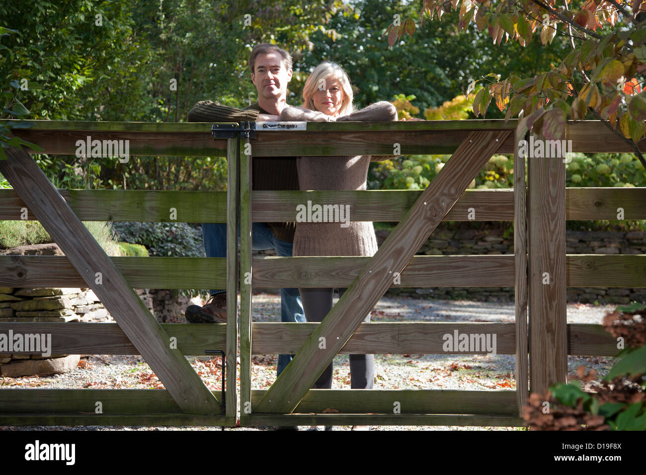 Giovane appoggiata sul cancello di legno Foto Stock