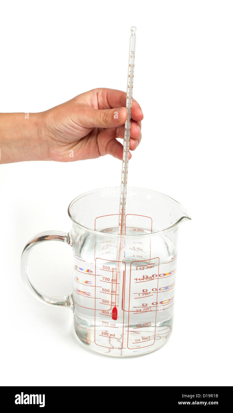 Termometro rileva la temperatura dell'acqua nel bicchiere con scala.tenere in mano il termometro Foto Stock