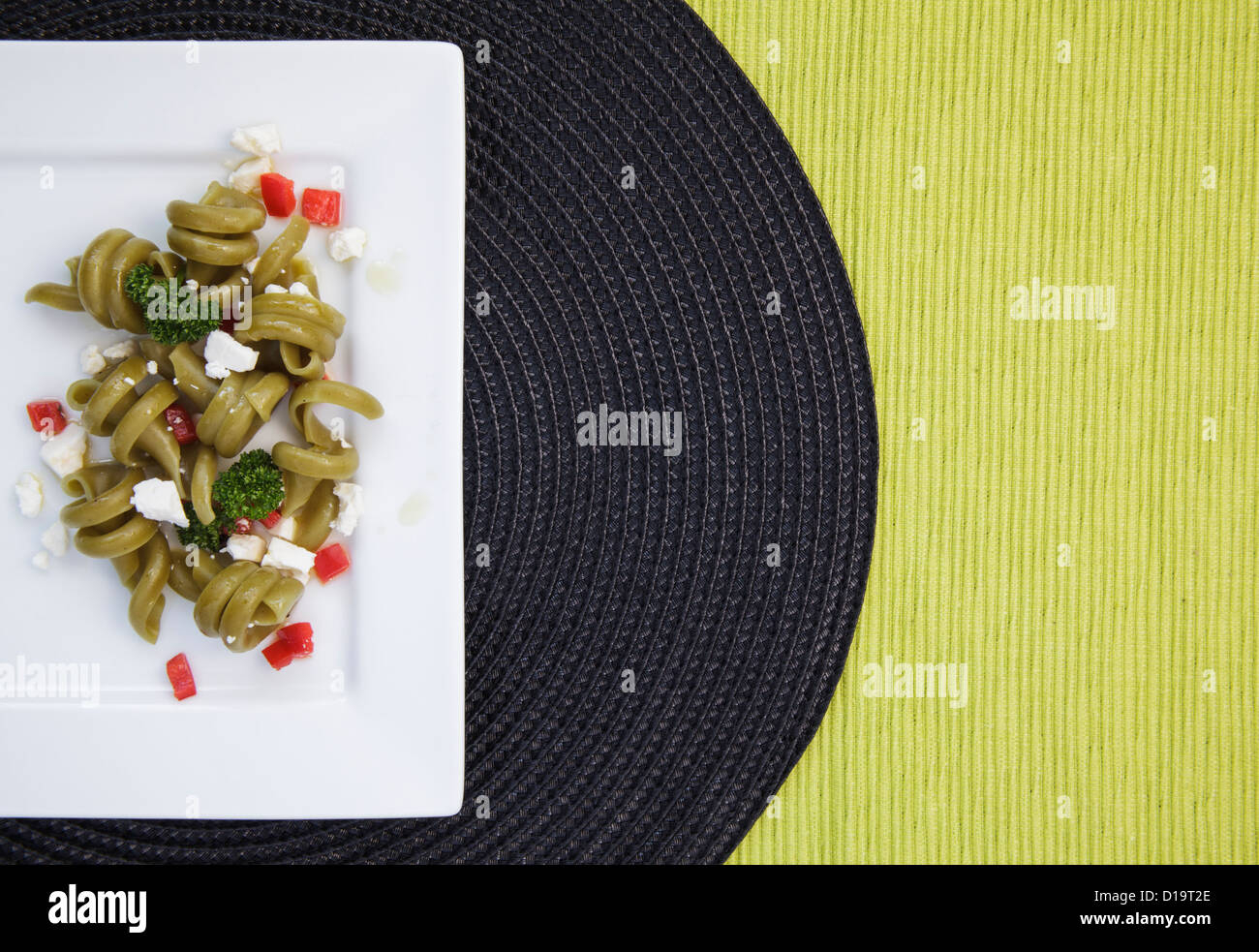 Gli spinaci trottole insalata di pasta sulla piazza piastra bianca Foto Stock