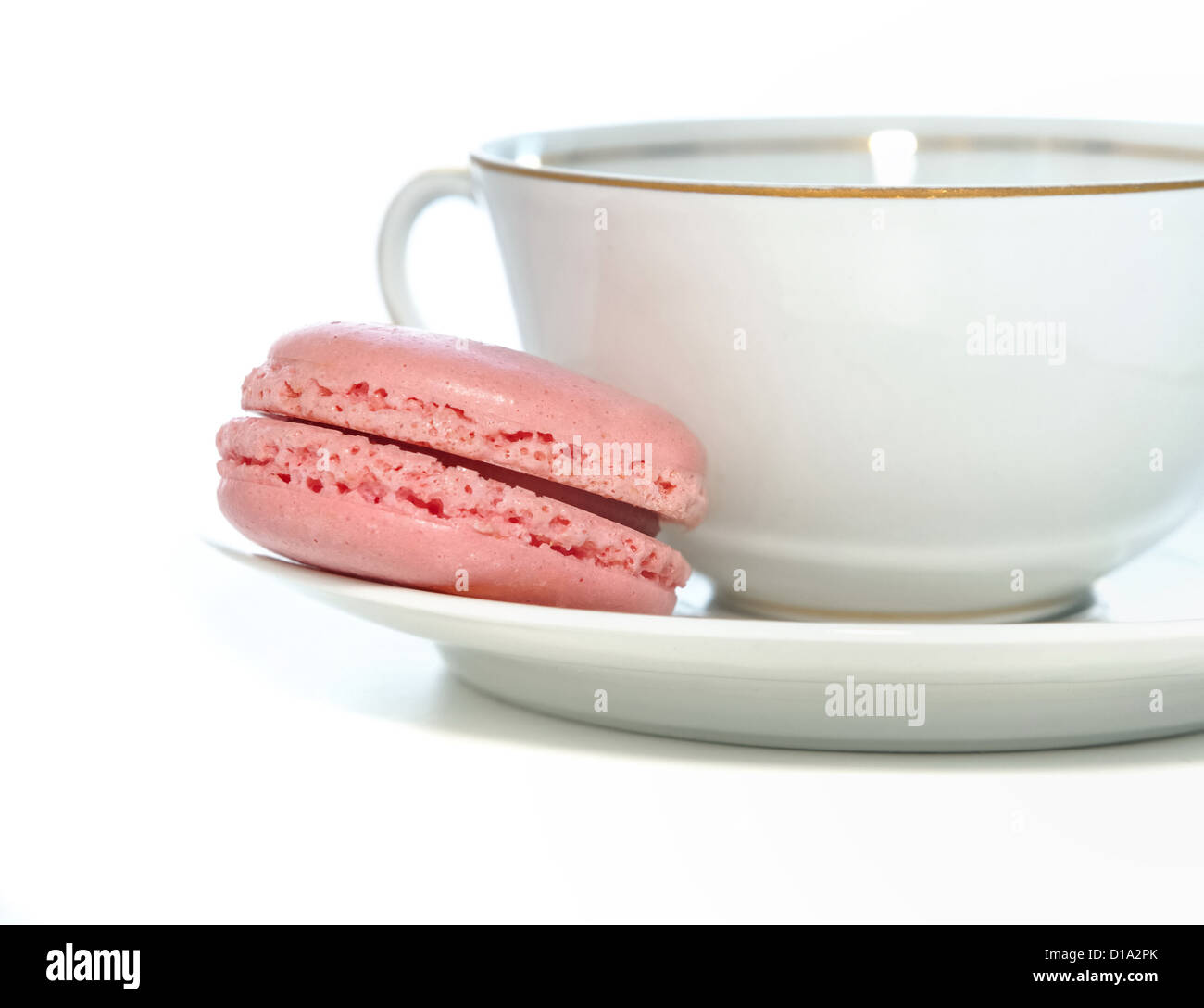Un amaretto rosa immessi sul piattino è passata da una tazza di porcellana di caffè Foto Stock