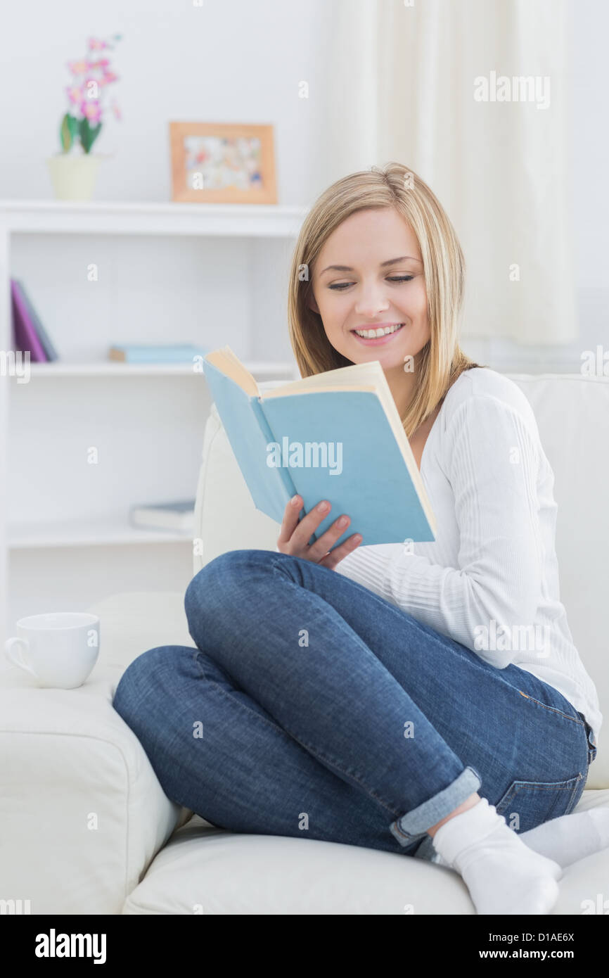 Felice giovane donna lettura storybook a casa Foto Stock