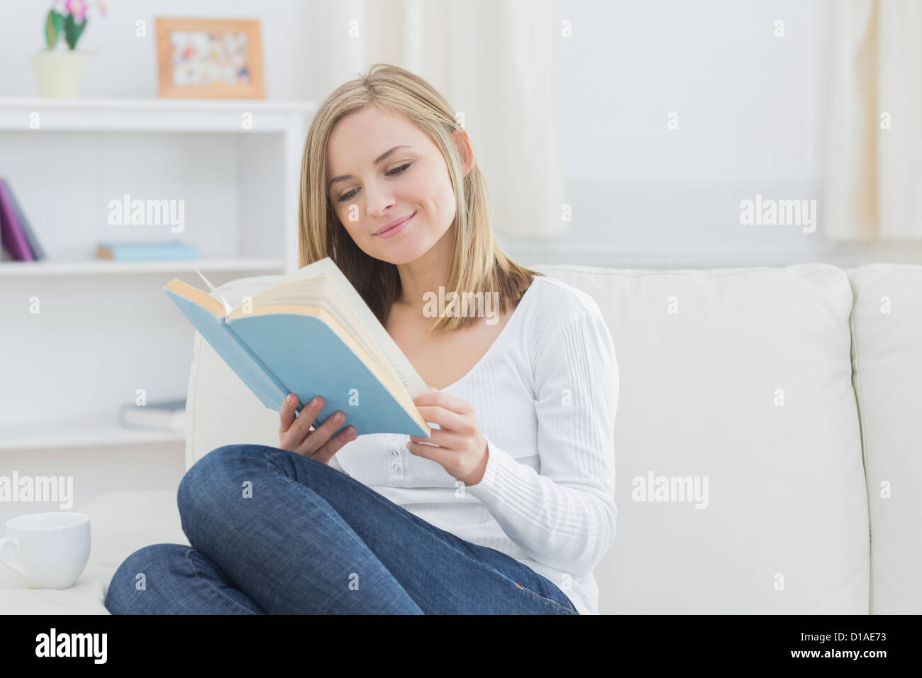Donna felice lettura storybook a casa Foto Stock