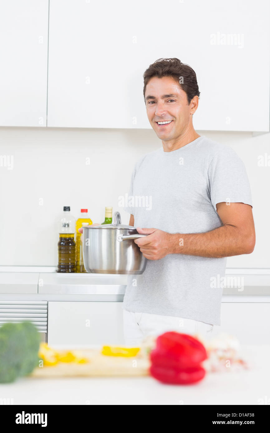 Uomo sorridente che porta POT Foto Stock