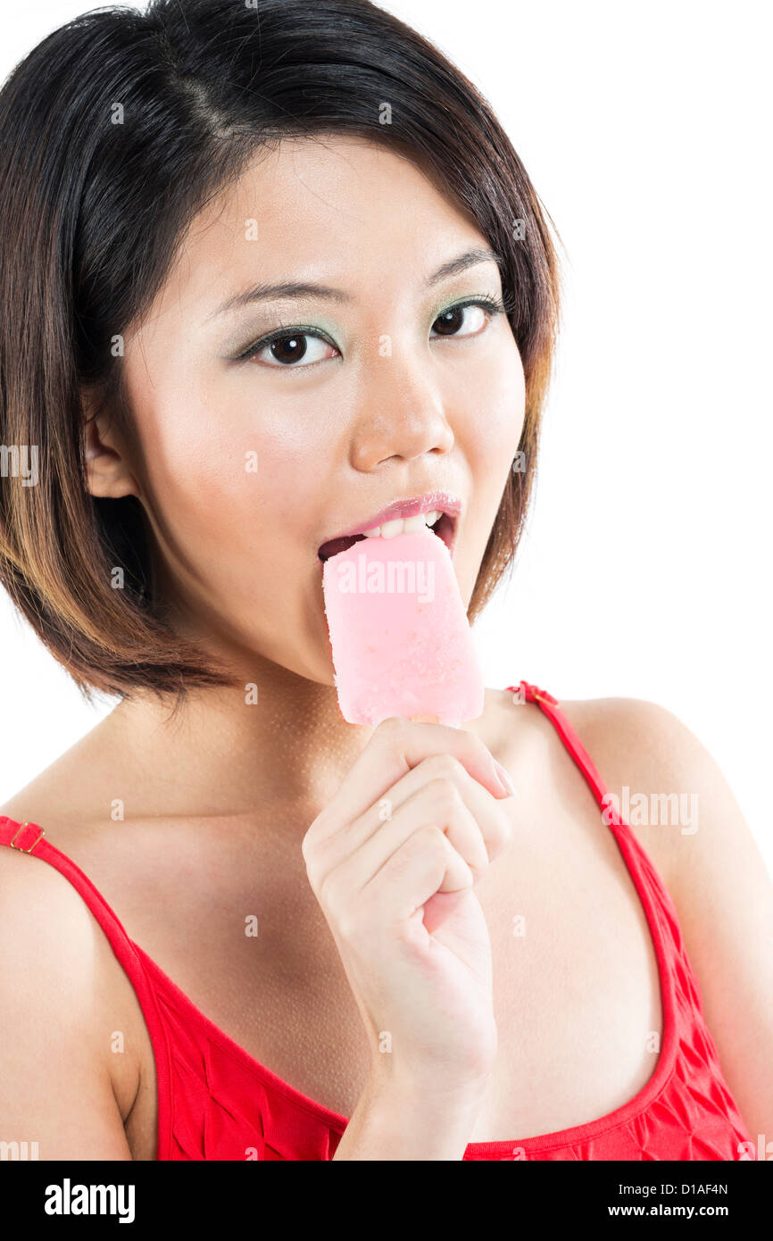 Donna cinese di mangiare un ice per lecca-lecca. Isolato su bianco. Foto Stock
