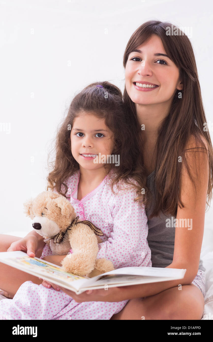 Madre e figlia insieme di lettura con Teddy bear Foto Stock