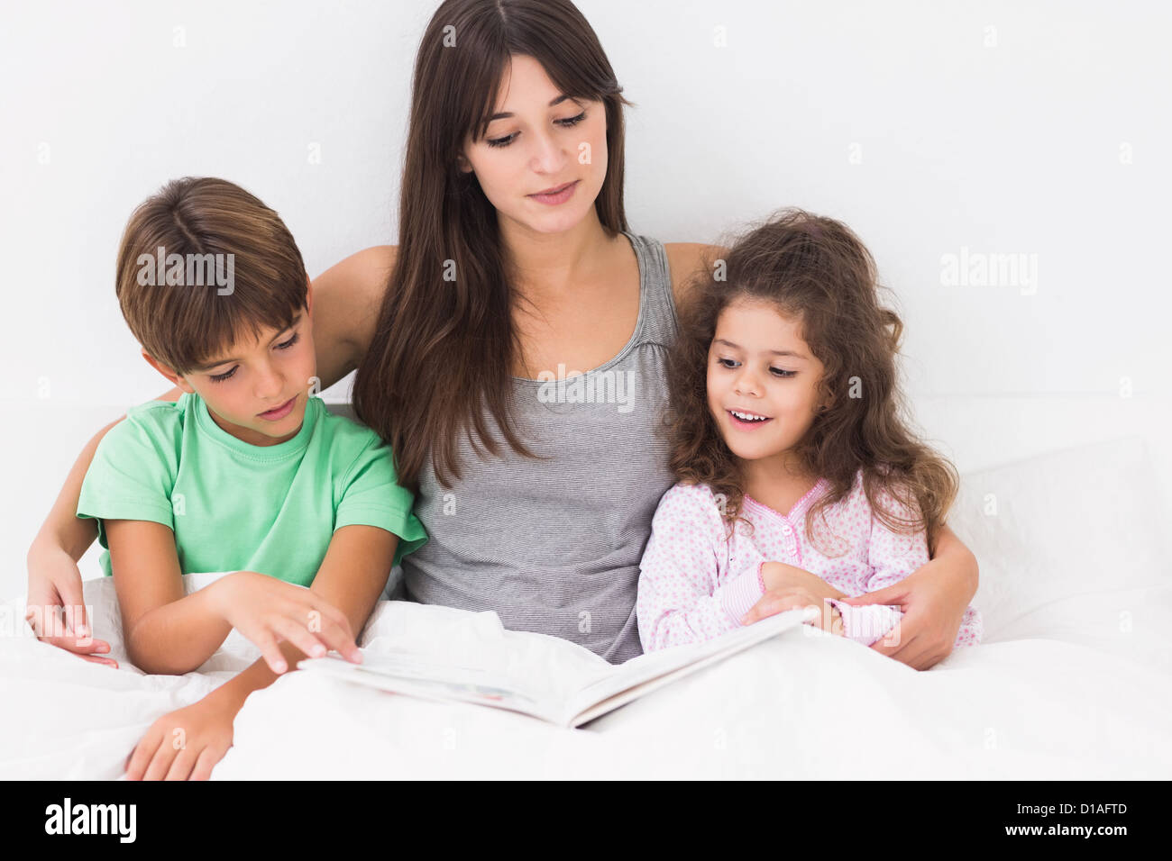 Madre e bambini lettura storybook Foto Stock