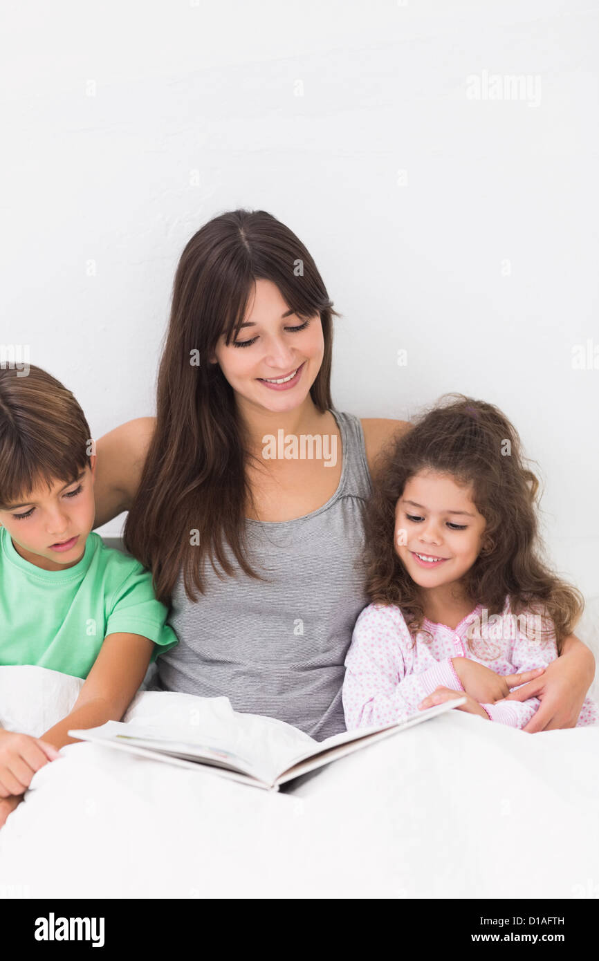 Madre e bambini libro lettura insieme Foto Stock