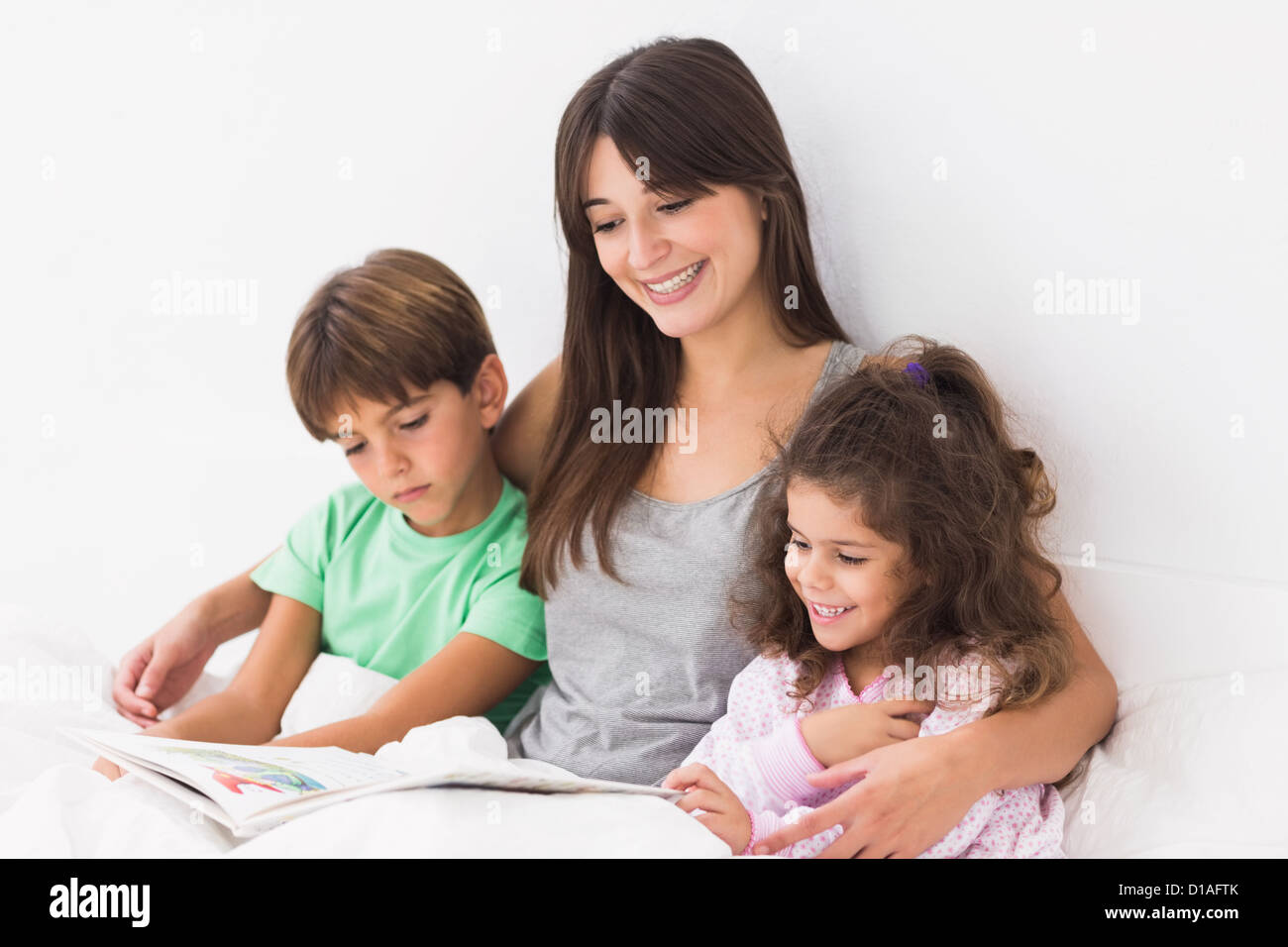 Madre con i suoi figli la lettura di un libro delle fiabe Foto Stock