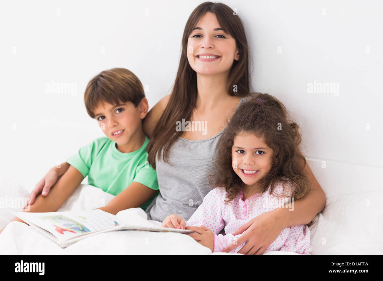 La madre con il figlio e la figlia del libro di lettura Foto Stock
