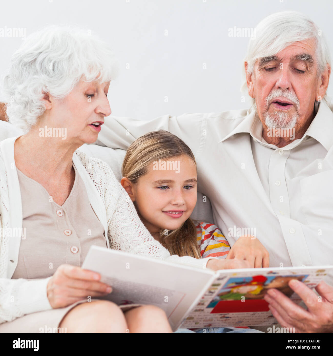 Bambina la lettura con i nonni Foto Stock