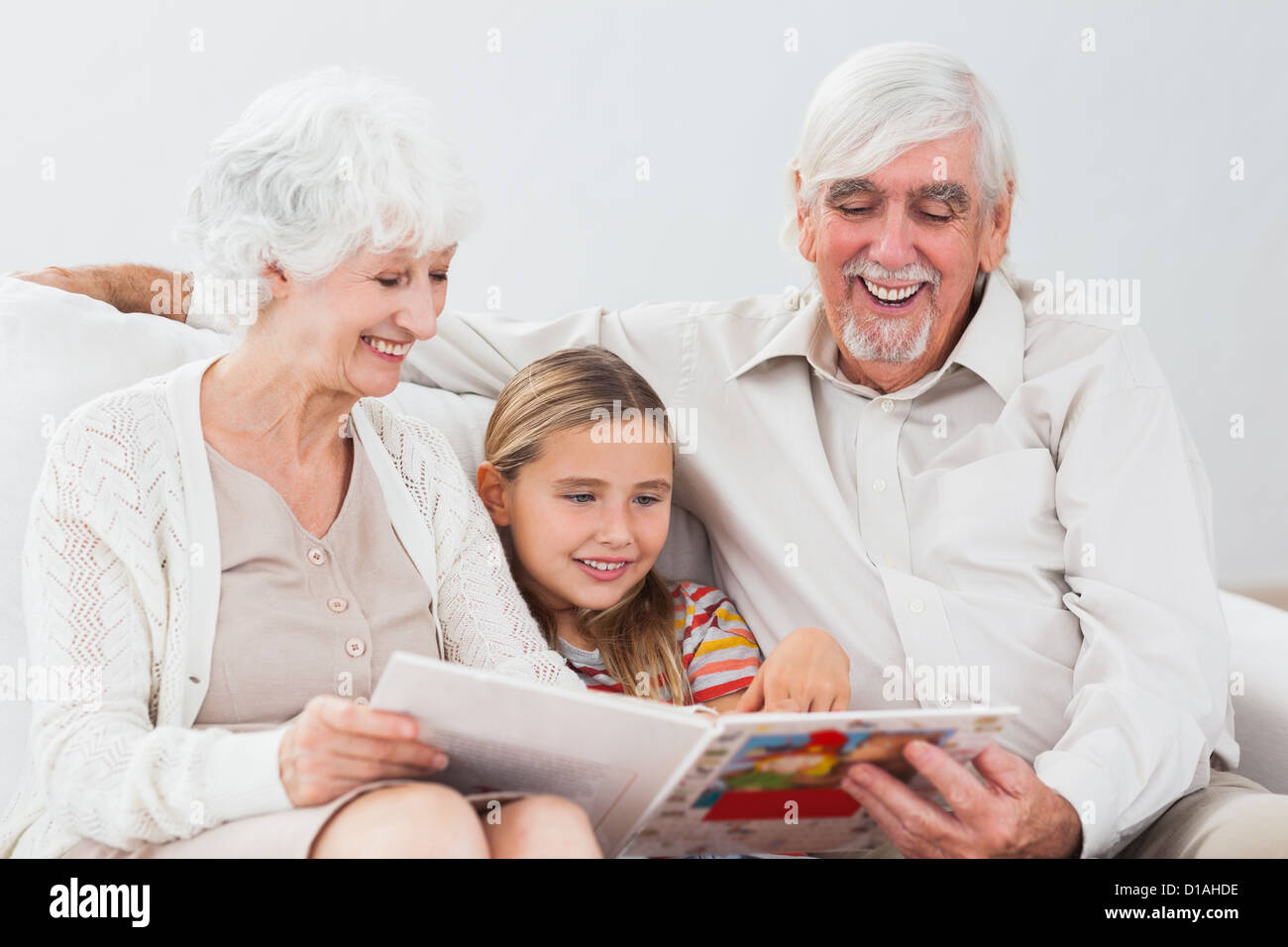 Felice bambina la lettura con i nonni Foto Stock