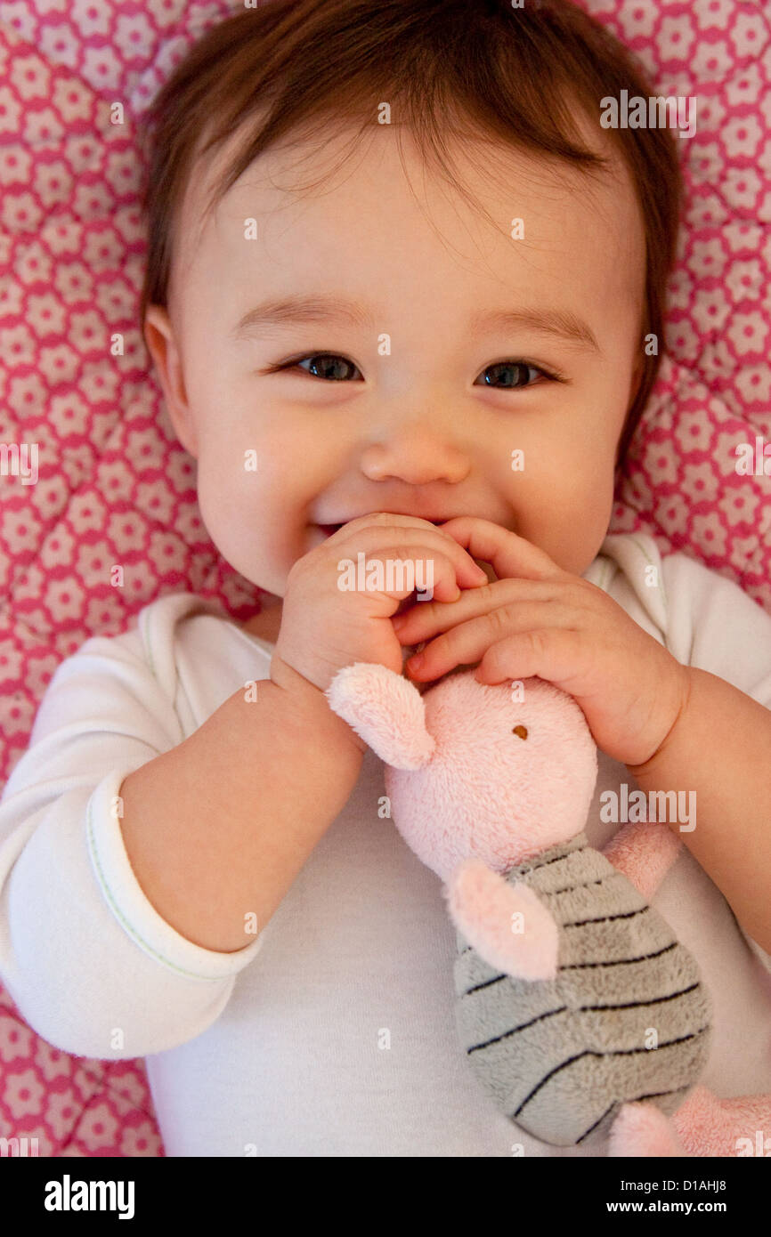 Undici mesi baby ragazza con il suo giocattolo Foto Stock