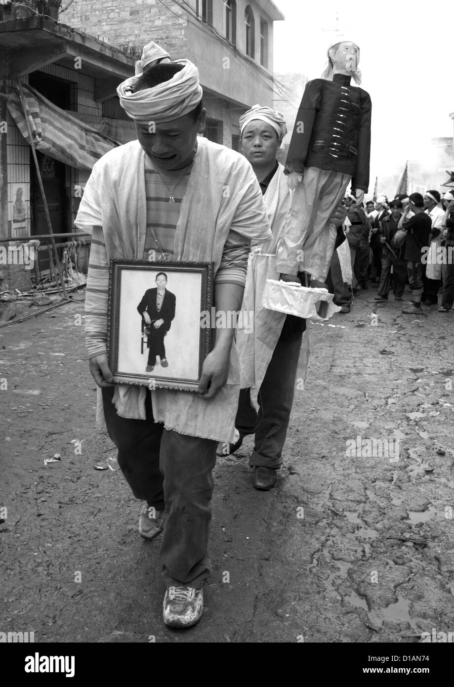 Uomo con la foto dei morti durante il corteo funebre, Yuanyang, nella provincia dello Yunnan in Cina Foto Stock