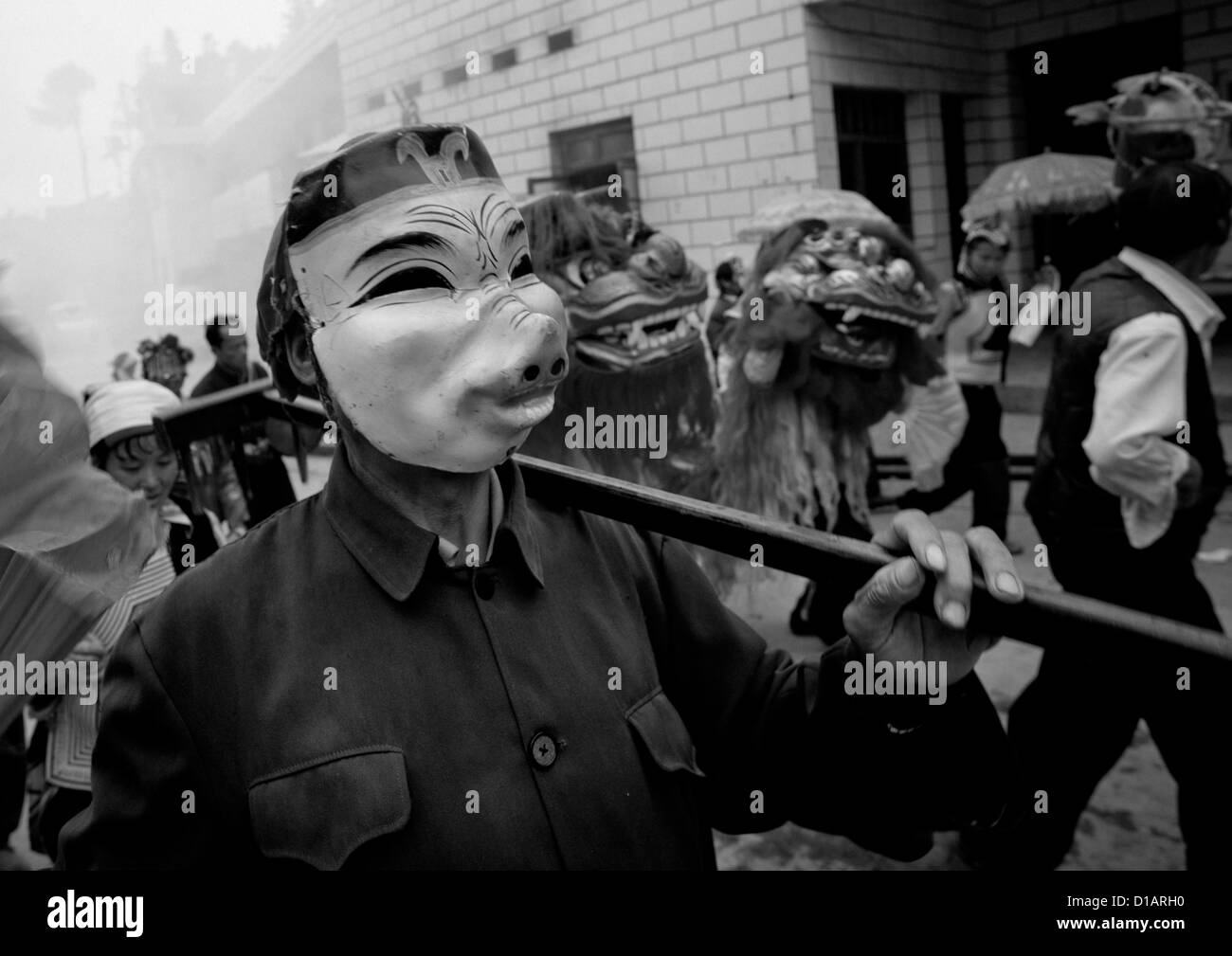 Uomo con una maschera di maiale durante una processione funebre, Yuanyang, nella provincia dello Yunnan in Cina Foto Stock