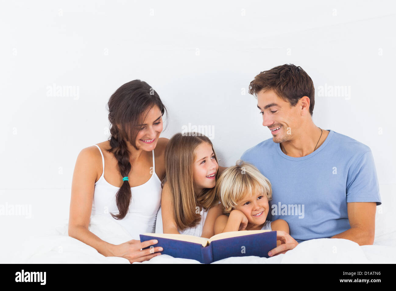 Famiglia seduta con un libro Foto Stock