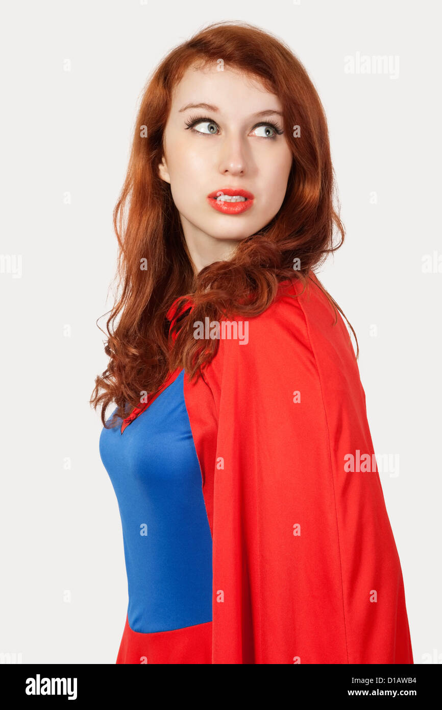 Giovane donna in costume da supereroe che guarda lontano Foto Stock