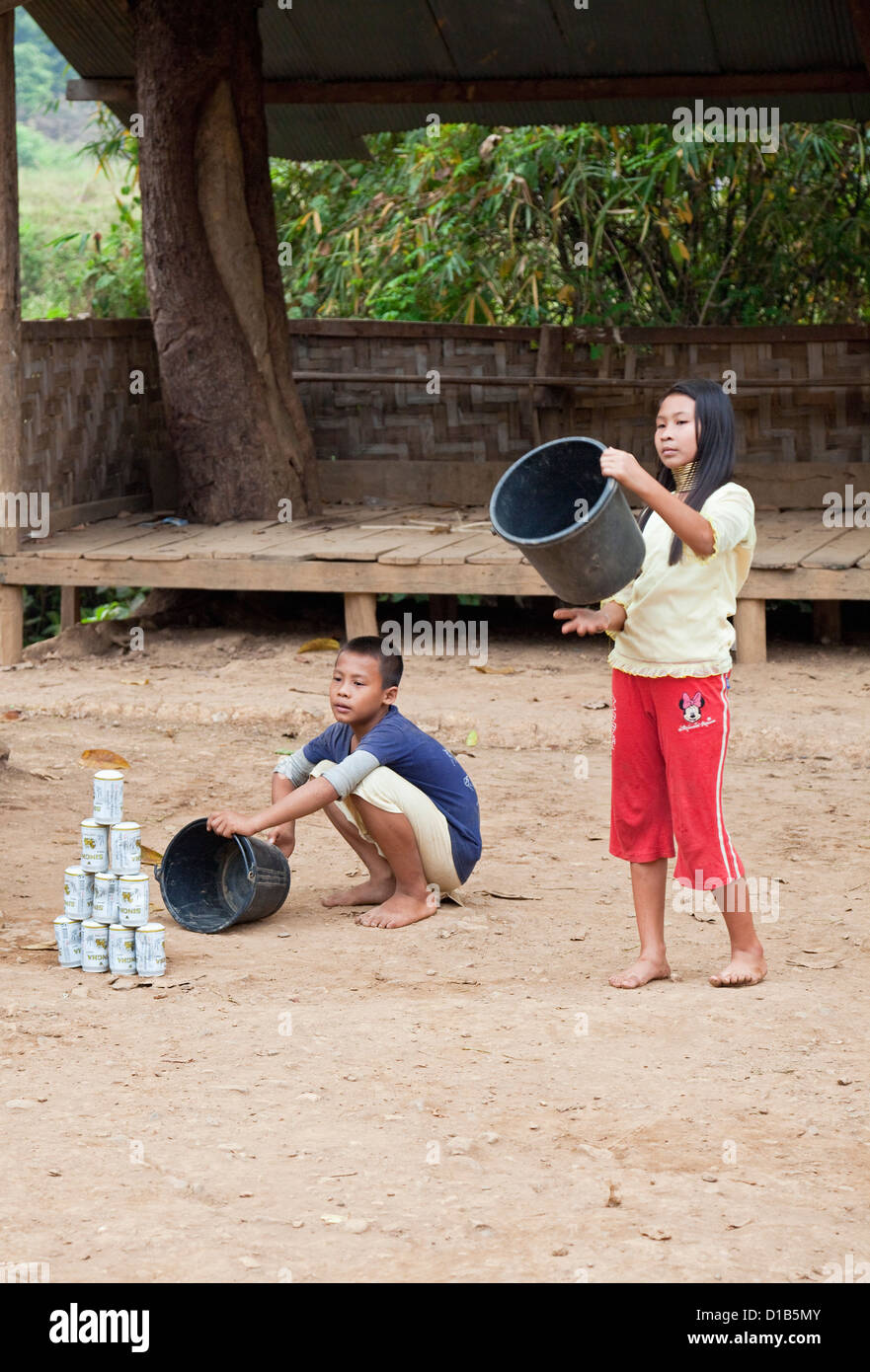 I bambini dalla minoranza Kayan gruppo giocando a un gioco simile a cricket, Huai Seau Tao, Mae Hong Son Provincia, Thailandia Foto Stock