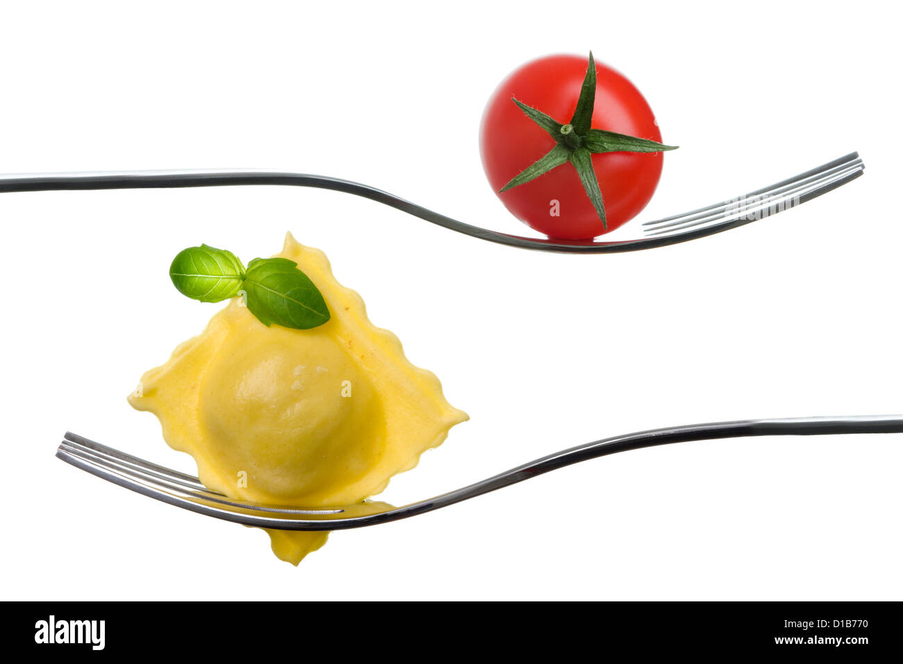 Ravioli e pomodoro ciliegino su una forcella con basilico guarnire contro uno sfondo bianco. cibo tradizionale italiano concept Foto Stock