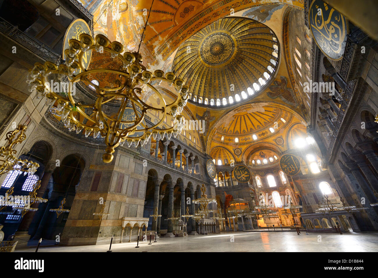 La luce del mattino in un vuoto di Hagia Sophia con lampadari e cupola dorata Istanbul TURCHIA Foto Stock