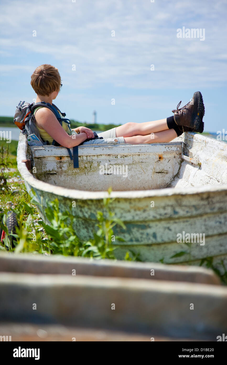 Da Helnaes, Danimarca, una donna seduta su una barca e si diverte a guardare Foto Stock