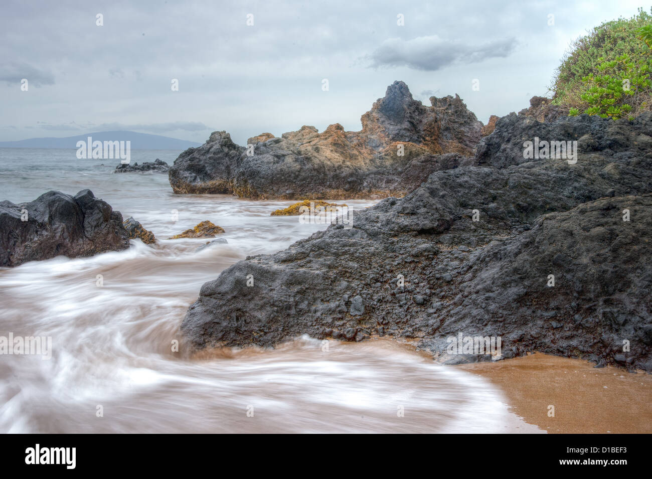 Maui roccioso litorale con lenta onde in movimento Foto Stock