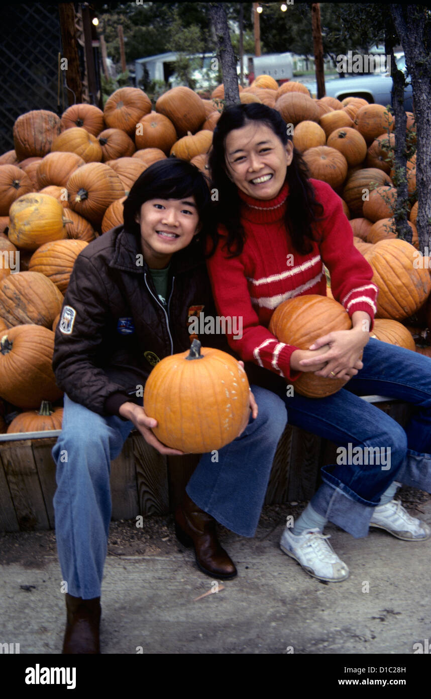 Chinesewoman e figlio posano con zucche di zucca farm durante la caduta stagione di ringraziamento Foto Stock
