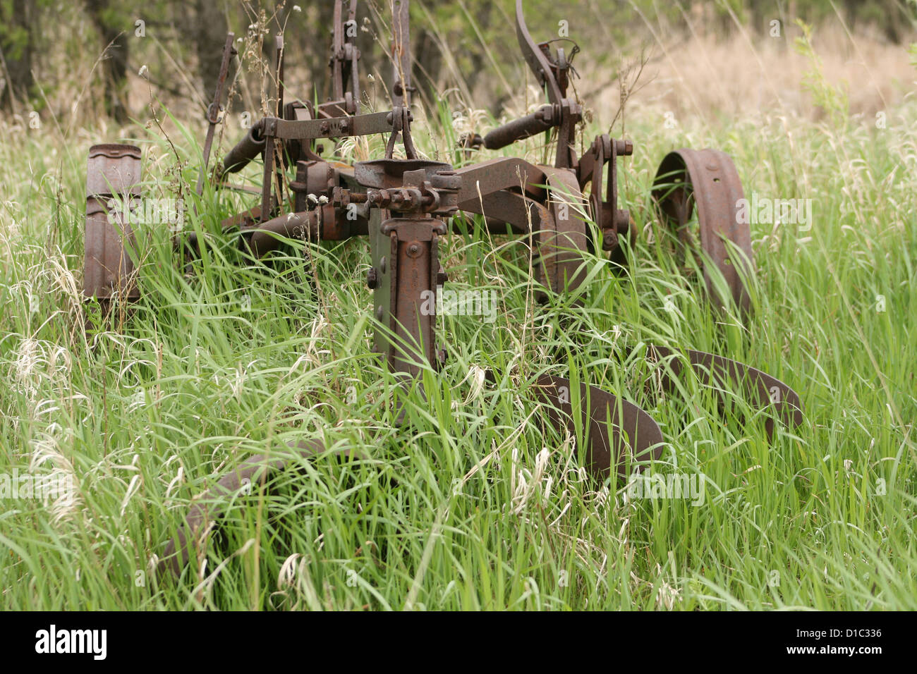 Un antico aratro ricoperta da erba in un campo di agricoltori in primavera a Winnipeg, Manitoba, Canada Foto Stock