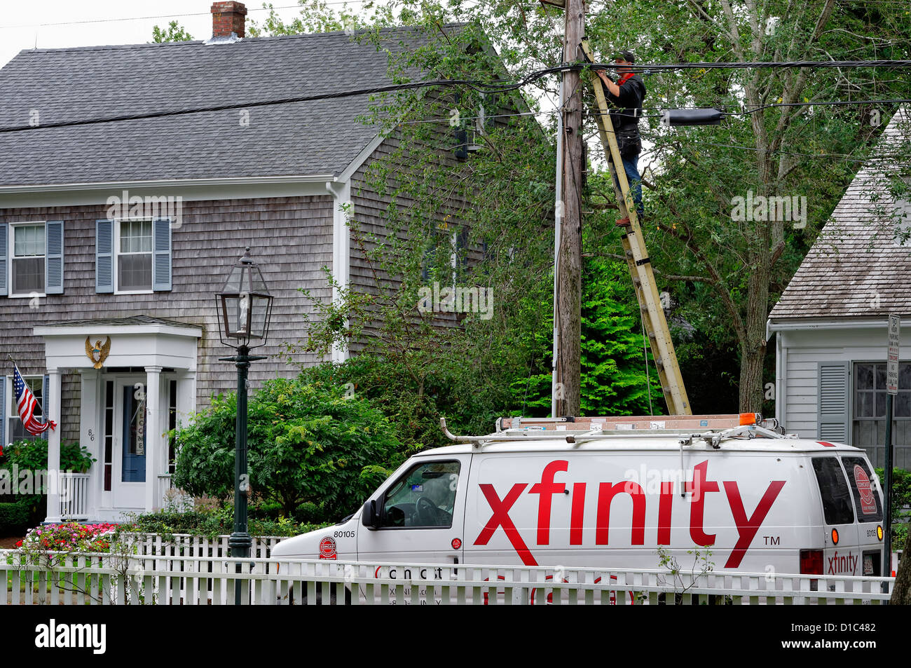 Comcast lavoratore intalls xfinity servizio via cavo a casa residenziale, Martha's Vineyard, Massachusetts, STATI UNITI D'AMERICA Foto Stock