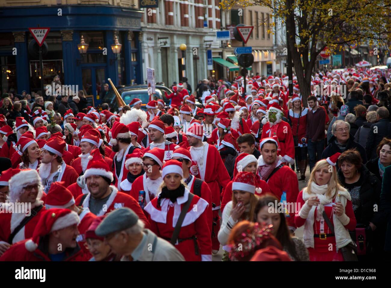 Londra, Regno Unito. Il 15 dicembre 2012 il grande raduno di Santa Con si muove in alto di Long Acre verso Covent Garden guidato da una banda di samba. Credito: Nelson pereira / Alamy Live News Foto Stock