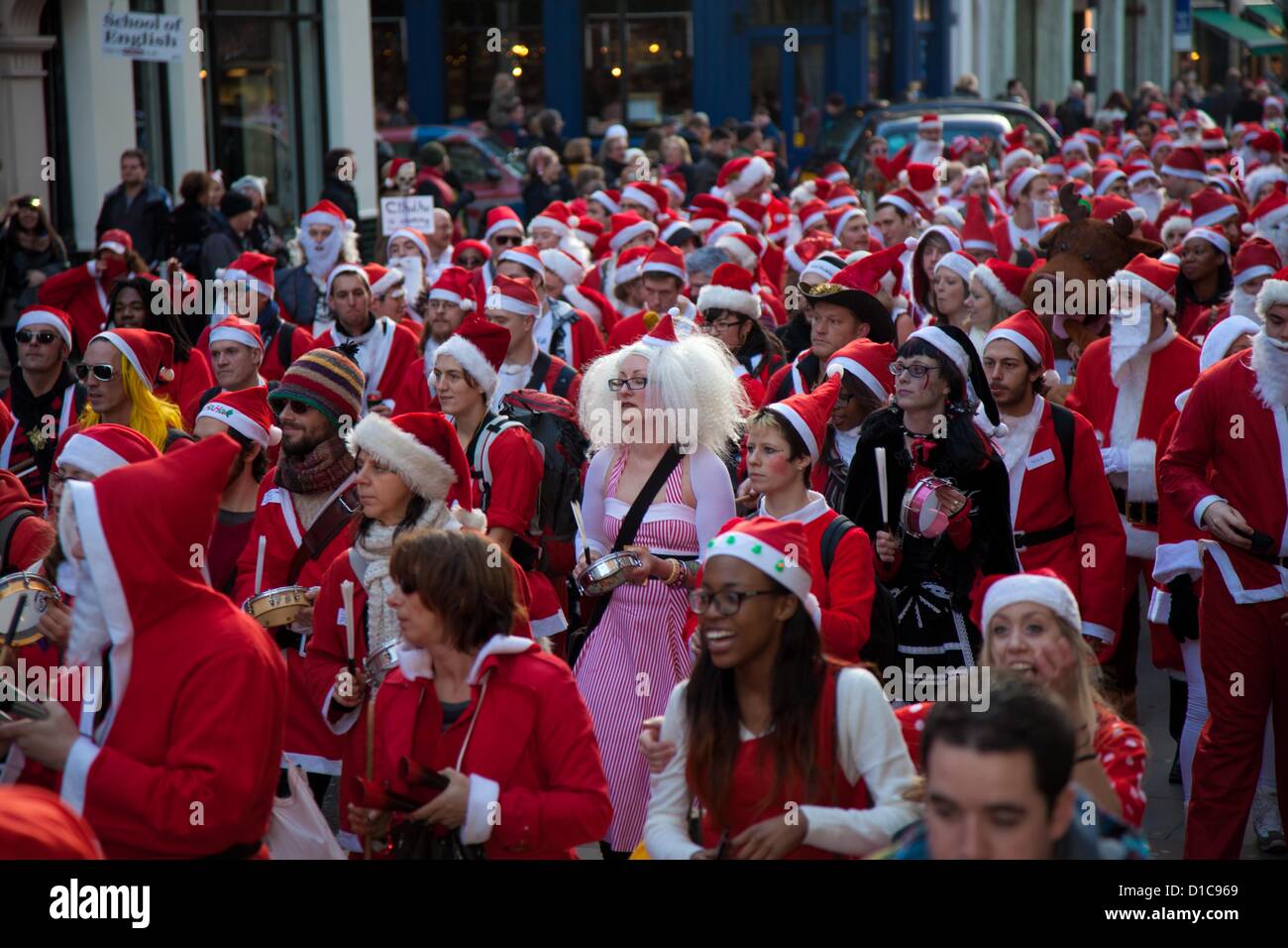 Londra, Regno Unito. Il 15 dicembre 2012 il grande raduno di Santa Con si muove in alto di Long Acre verso Covent Garden guidato da una banda di samba. Credito: Nelson pereira / Alamy Live News Foto Stock