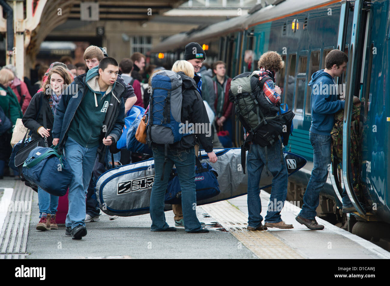 Aberystwyth, Wales, Regno Unito, 15 Dicembre 2012: gruppi di giovani studenti delle università e dei college borse e zaini di bagagli cattura il Galles arriva il treno da Aberystwyth stazione ferroviaria alla fine del termine, tornando a casa alle loro famiglie per le vacanze di Natale in vacanza Foto Stock