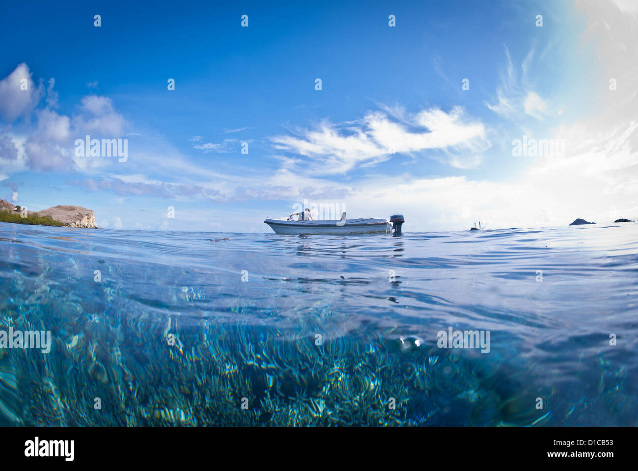 Una gara in barca di Komodo parco marino in attesa per il subacqueo di superficie. Una giornata di sole con cielo azzurro e sole splendente e acqua turquosie Foto Stock