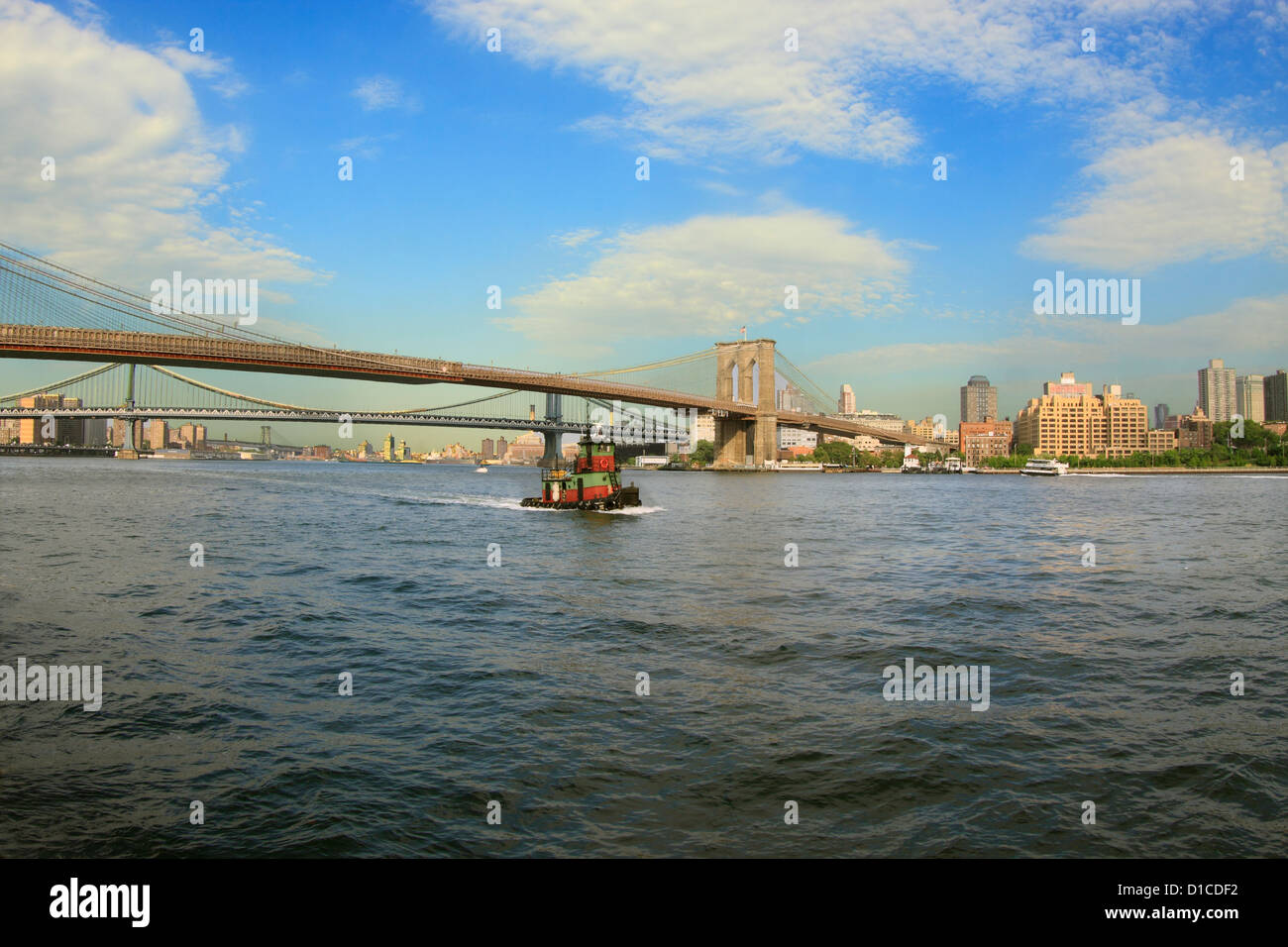 Rimorchiatore sull'East River con Brooklyn e ponti di Manhattan in background Foto Stock