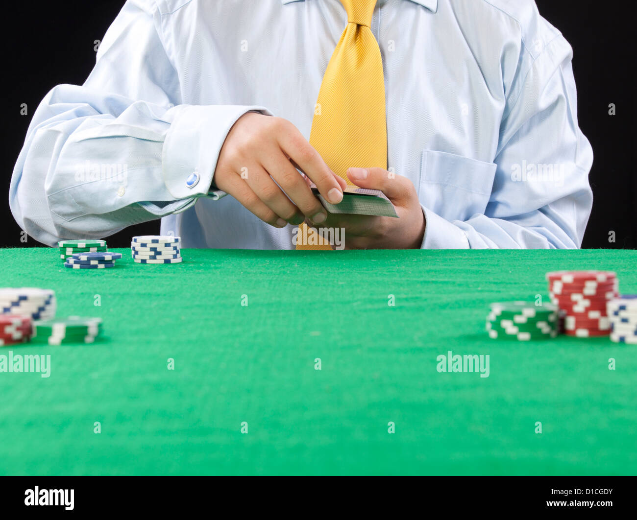 Giocatore di poker con una cravatta gialla che serve le carte Foto Stock