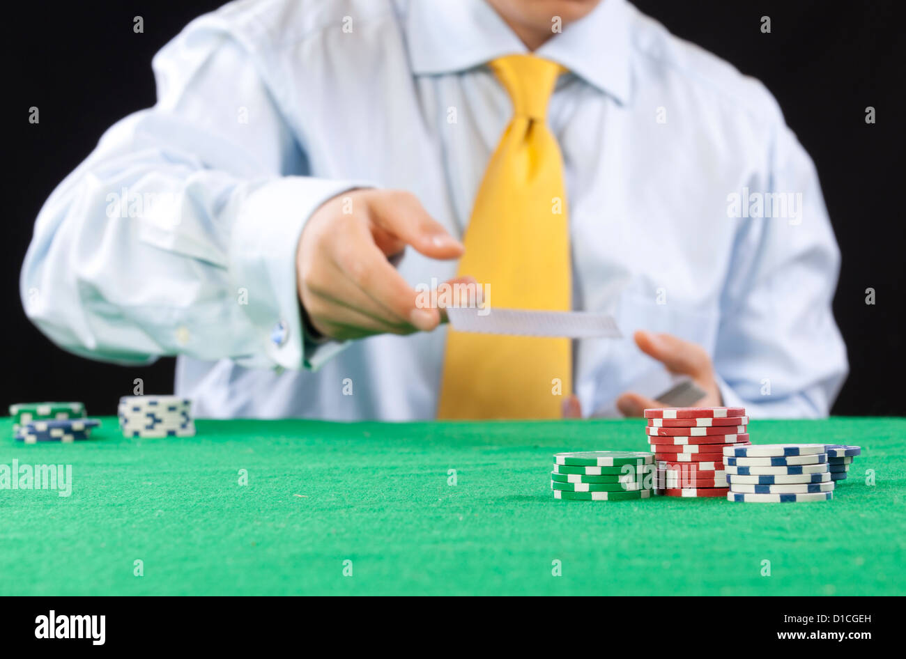 Giocatore di poker con una cravatta gialla che serve le carte Foto Stock
